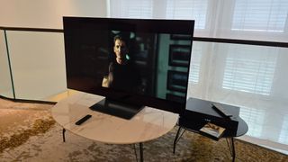 Samsung S90D 48-inch TV on a marble table with Top Gun Maverick playing on screen