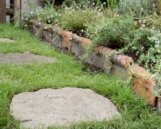 stepping stone path across a lawn with reclaimed garden edging materials