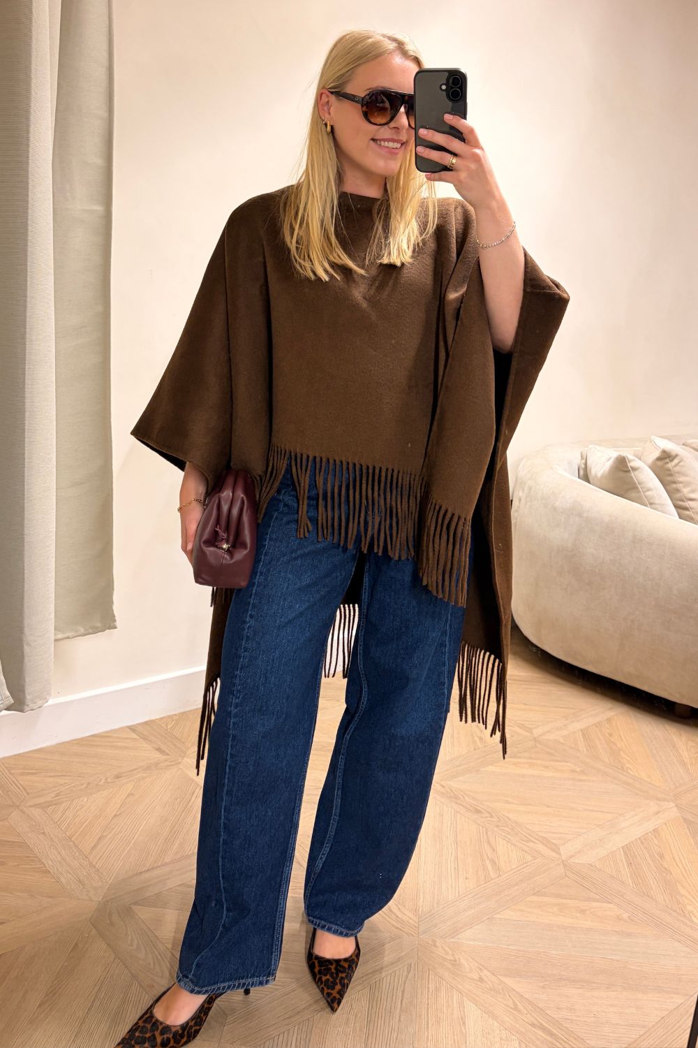 Shopping editor, Florrie, wears a brown fringe poncho, blue barrel-leg jeans, leopard print heels and burgundy clutch all from Marks &amp;amp; Spencer.