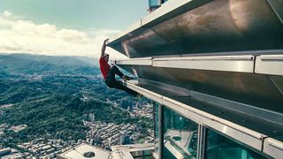 Alex Honnold high in the air as he climbs the Taipei 101 skyscraper