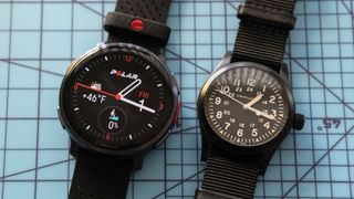 Polar Vantage V3 smartwatch next to a mechanical watch.