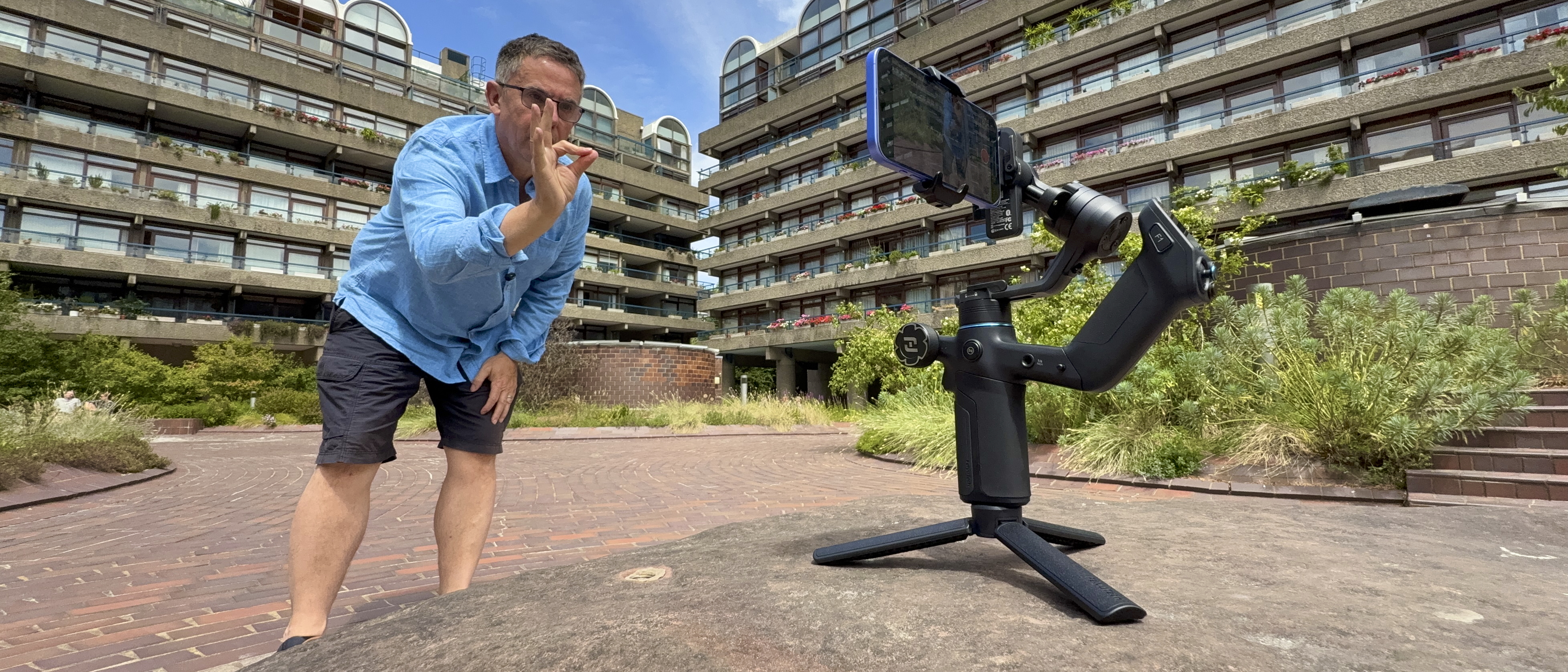 A wide shot showing the reviewer talking to a camera mounted in the Scorp Mini 3 Pro that is standing on its mini tripod