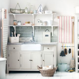 white laundry room with white shelves and cabinet