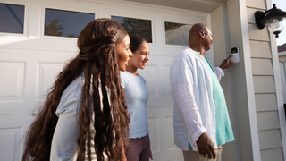 An image showing a family using a MyQ smart device on their home garage door