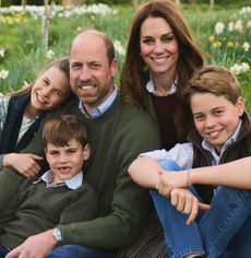 Prince William, Princess Kate, Princess Charlotte, Prince Louis and Prince George sitting in a field of flowers