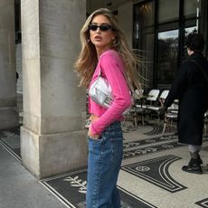 @emilisindlev wearing a silver Fendi baguette bag with pink cardigan and jeans