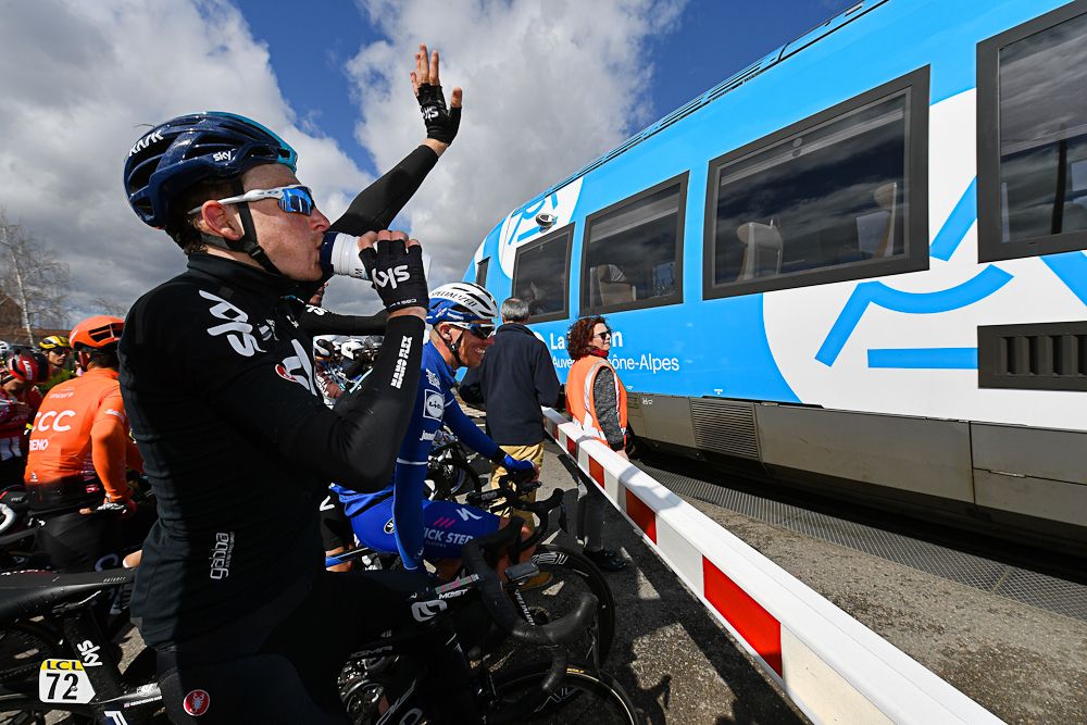 Tao Geoghegan Hart (Team Sky) waves to passengers on a train that momentarily halted stage 4 at Paris-Nice