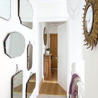 hallway with white wall and mirrors