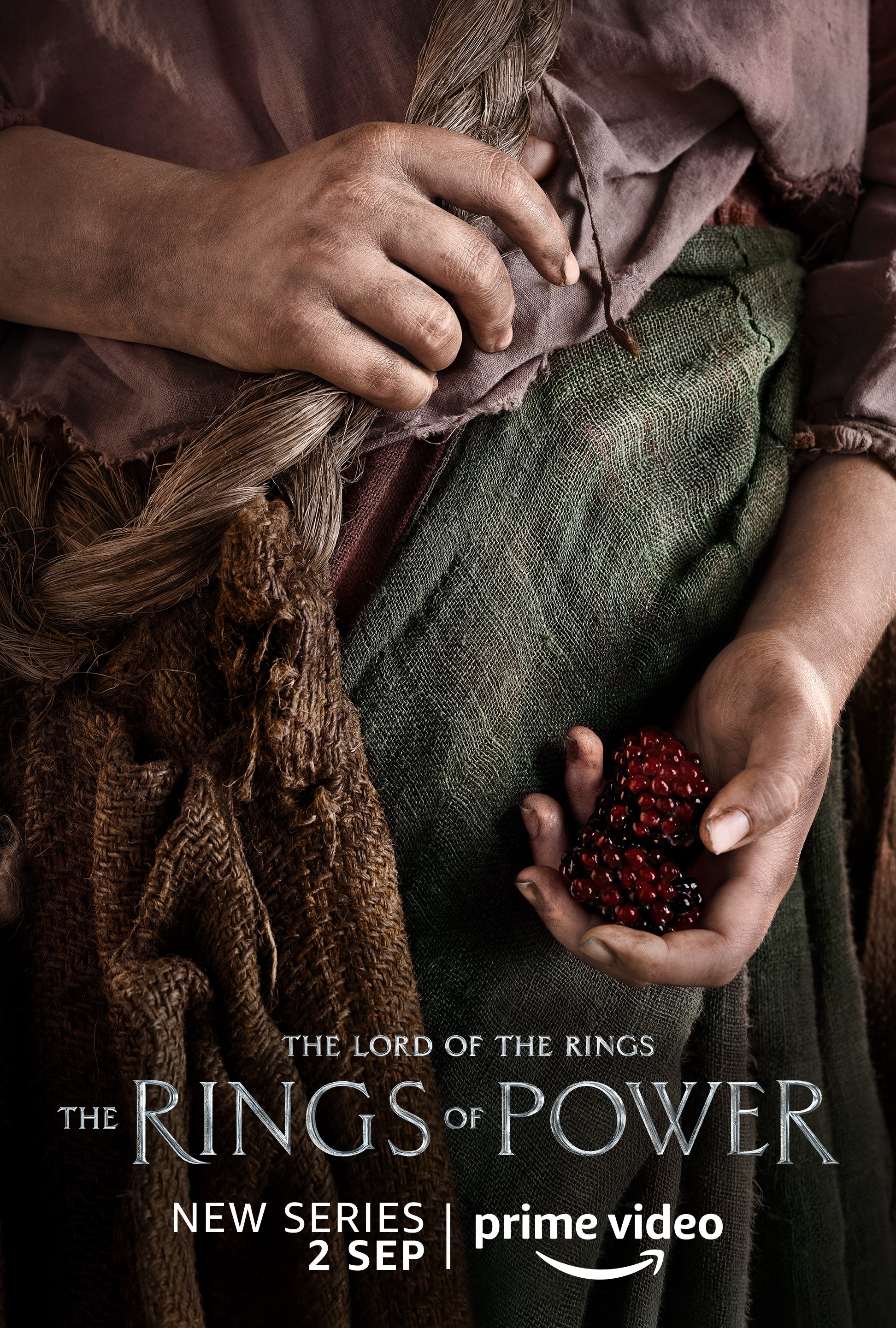 A person holding berries character poster for Lord of the Rings: The Rings of Power