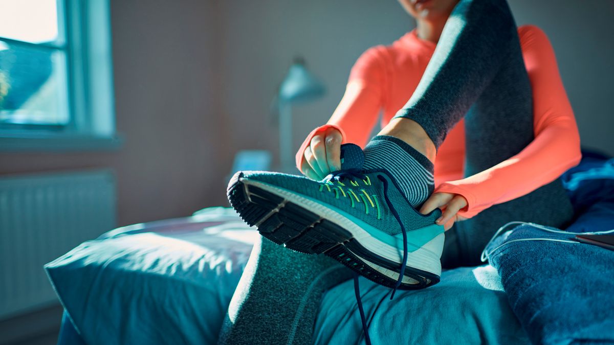 Woman wearing striped running socks putting on running shoes