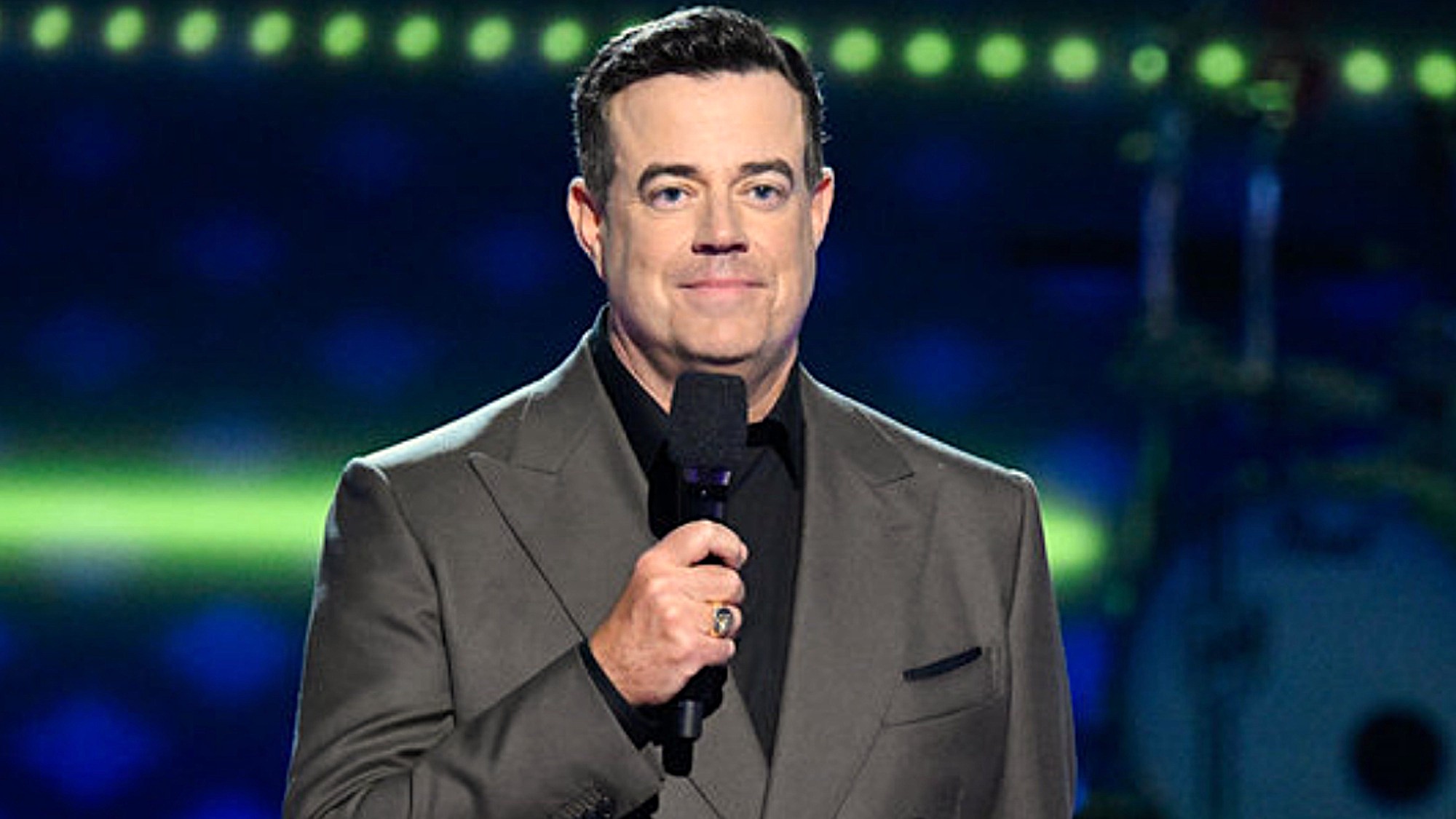 Carson Daly is shown hosting The Voice.