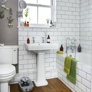 bathroom with white tiles and wooden floor and sink and bathtub and toilet