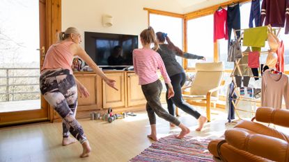 Family complete a walking based workout in a living room