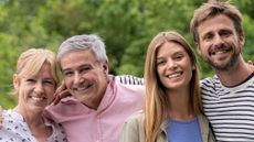 Portrait of smiling family with arms around each other in their garden