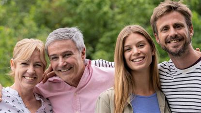 Portrait of smiling family with arms around each other in their garden