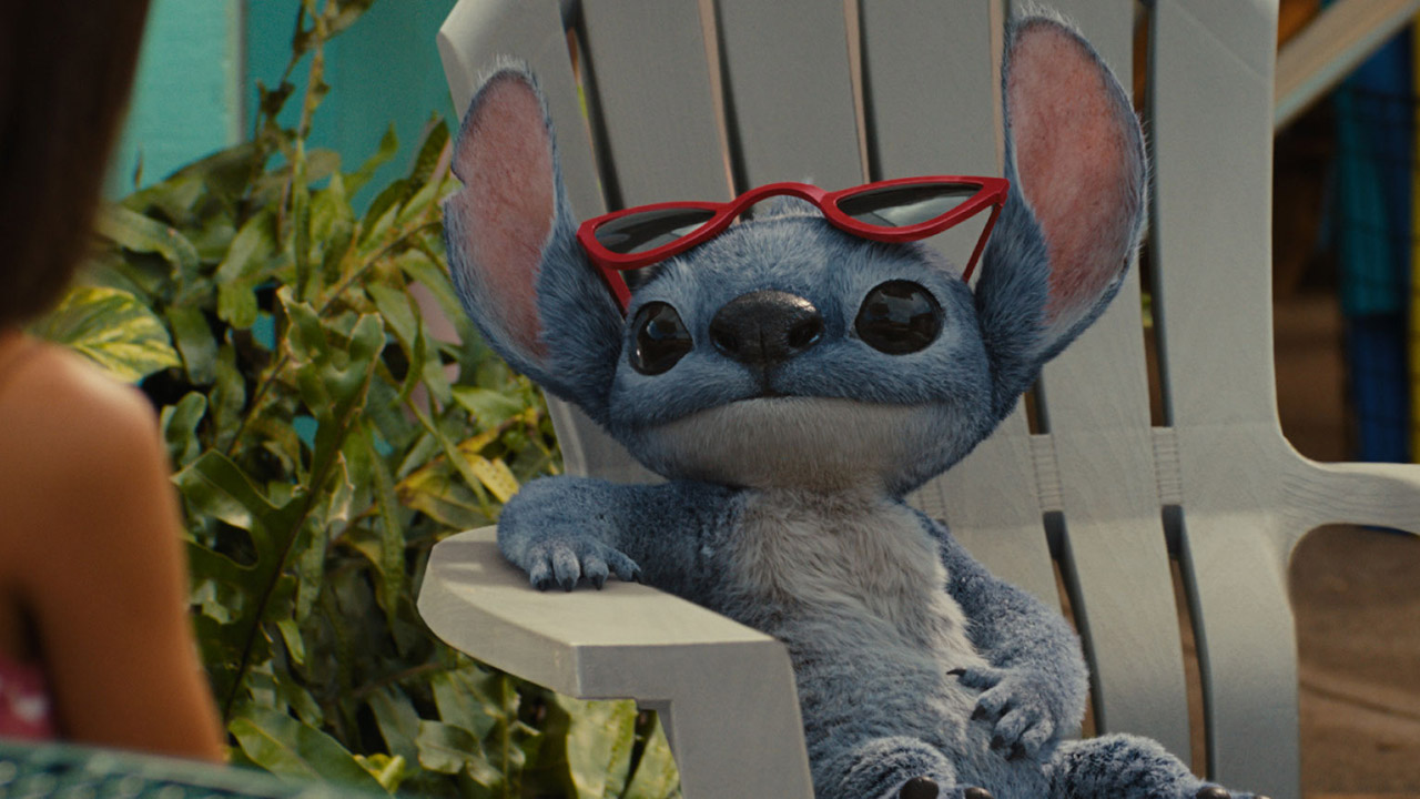 Lilo sitting on a white chair with red sunglasses perched on his head in Disney&#039;s Lilo &amp; Stitch live-action remake