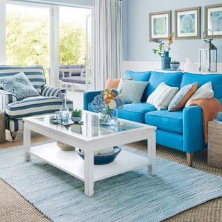 blue soft furnishings in living room with white coffee table