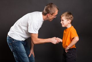 A dad shakes hands with his son.