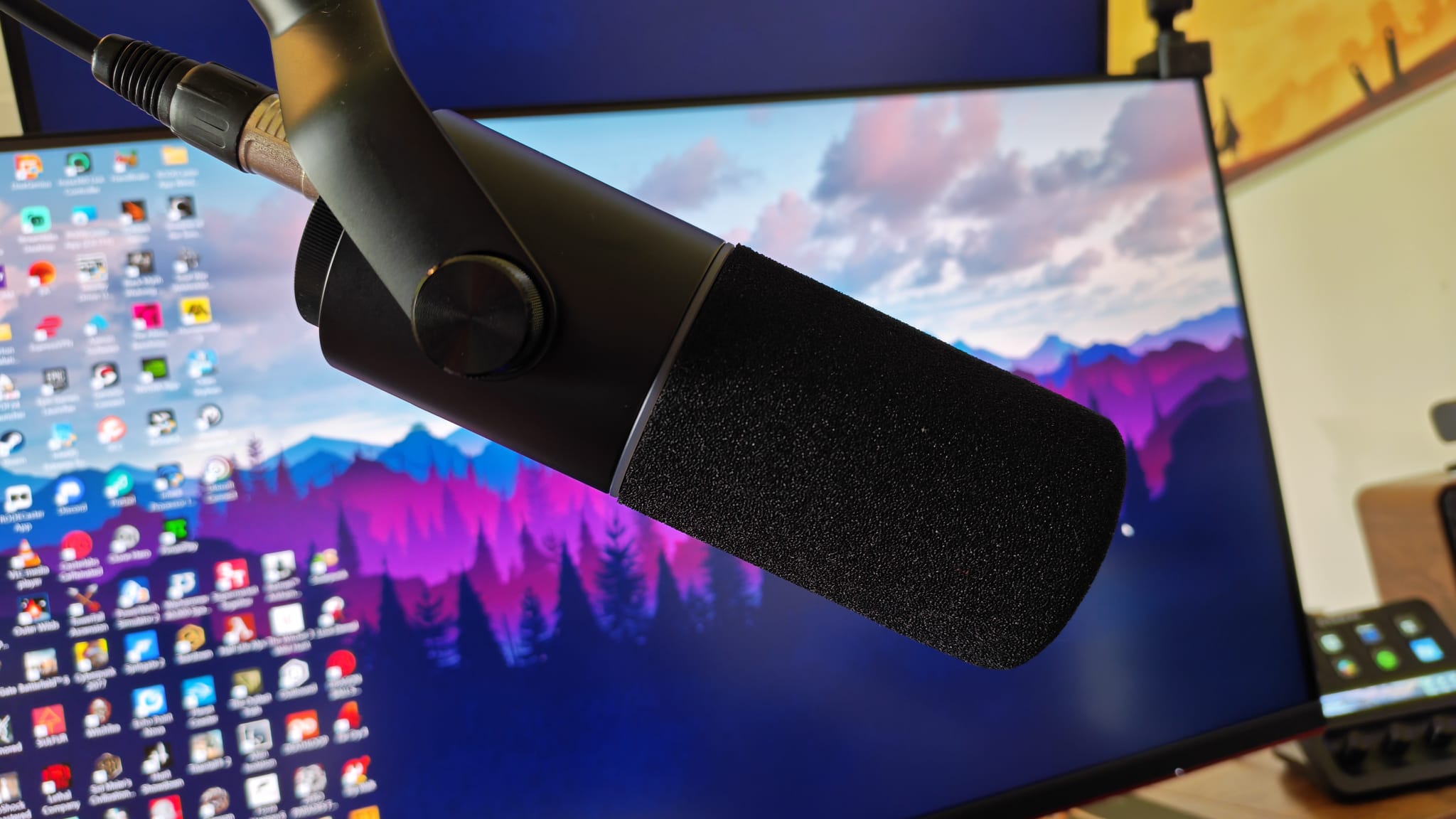 The Razer Seiren V3 Pro in front of a gaming monitor
