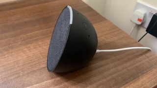 Amazon Echo Pop on a table, showing a side view of the semispherical form factor