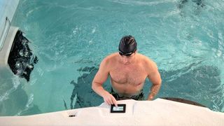 A man uses the digital control on his H2X Fitness spa pool to select a water resistance and speed