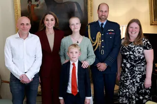 Kate Middleton and Prince William standing in front of a horse painting with teenage cancer patient Liz Hatton and her family