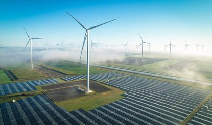 Solar energy and wind turbines in fog, seen from the air