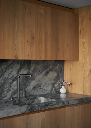 A kitchen with marble and wood accents