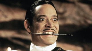 Raul Julia with a knife in his mouth in The Addams Family