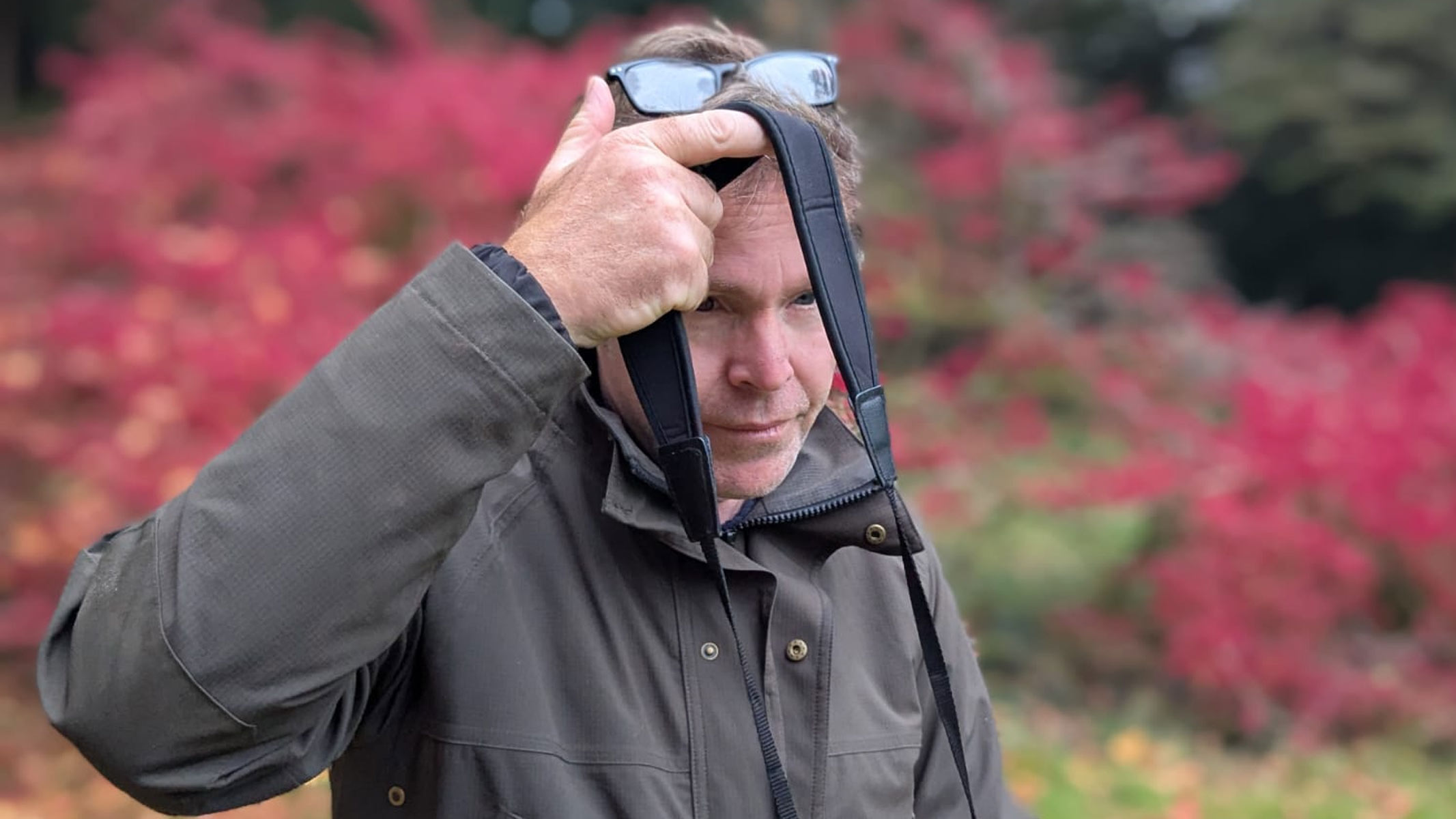 Our reviewer about to put the strap of the Carson VX 12x50 binoculars over his head.