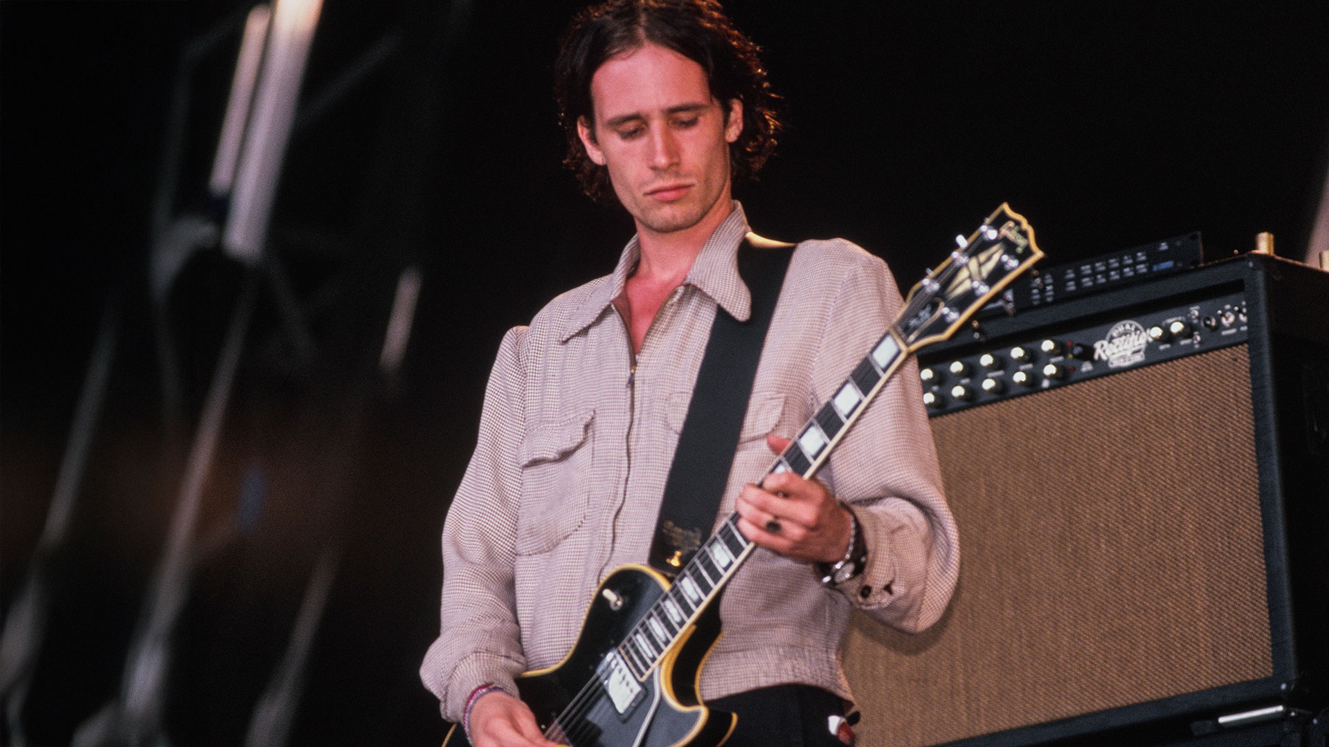 Jeff Buckley playing a black Gibson Les Paul guitar onstage at Glastonbury festival in the UK in 1995
