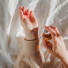 A woman spray perfume onto her wrist