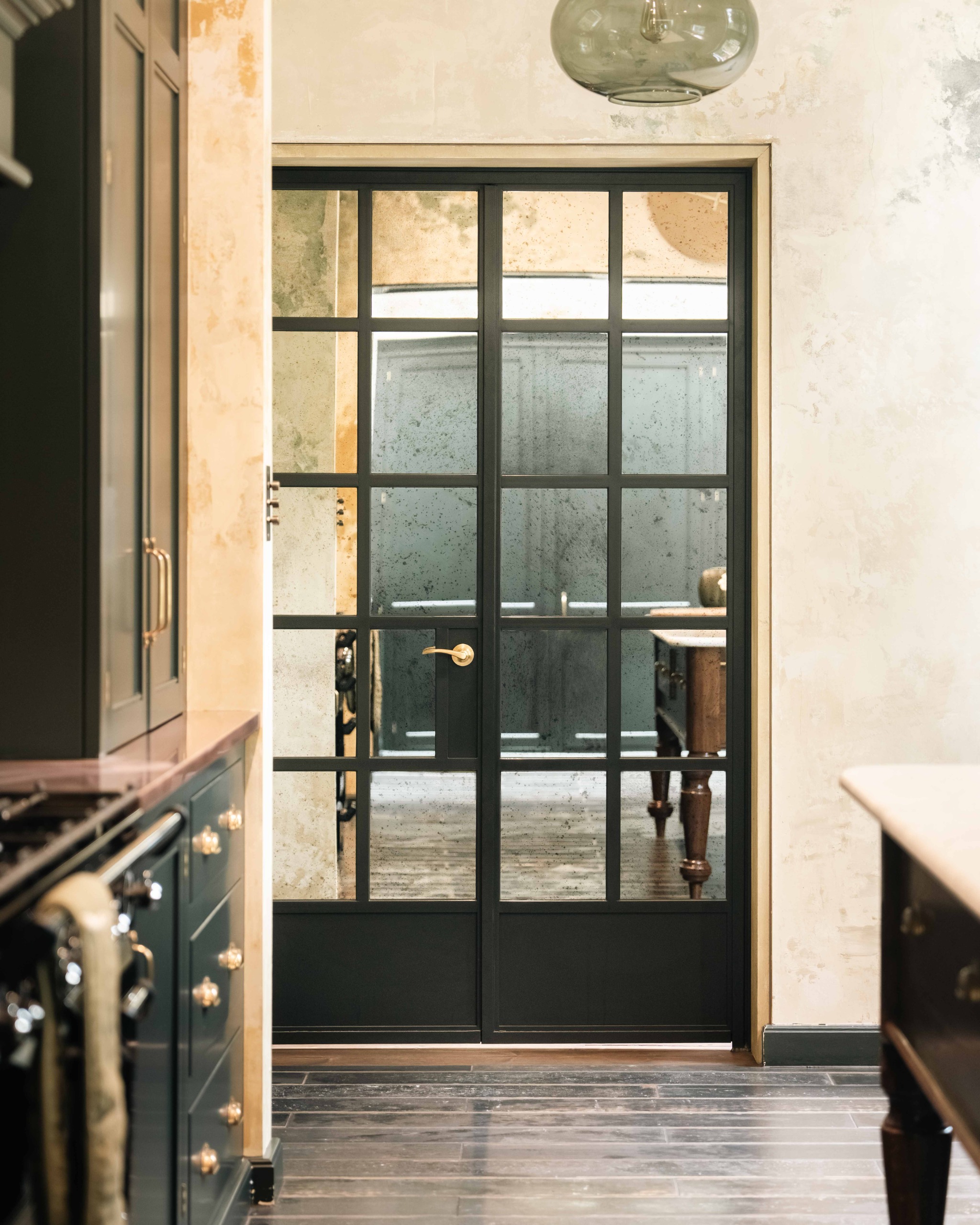 dark crittal doors in a traditional kitchen, with wooden floors and aged walls