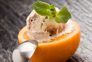 photo of cutted orange with ice cream and mint on it