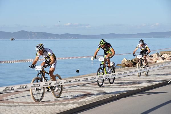 A Multivan Merida rider is sandwiched between two Scott Swisspower teammates.