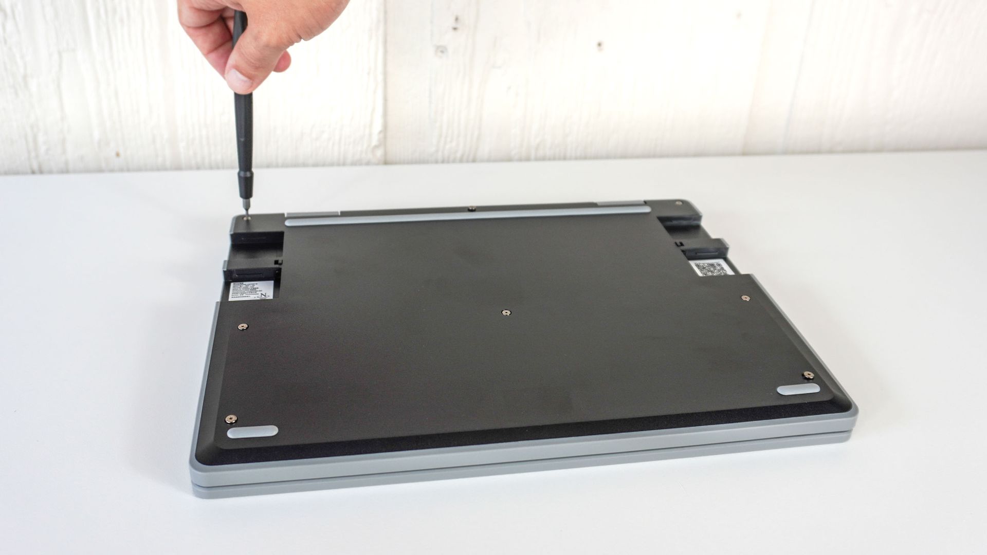 A person screwing in the Framework Laptop 12's case screws