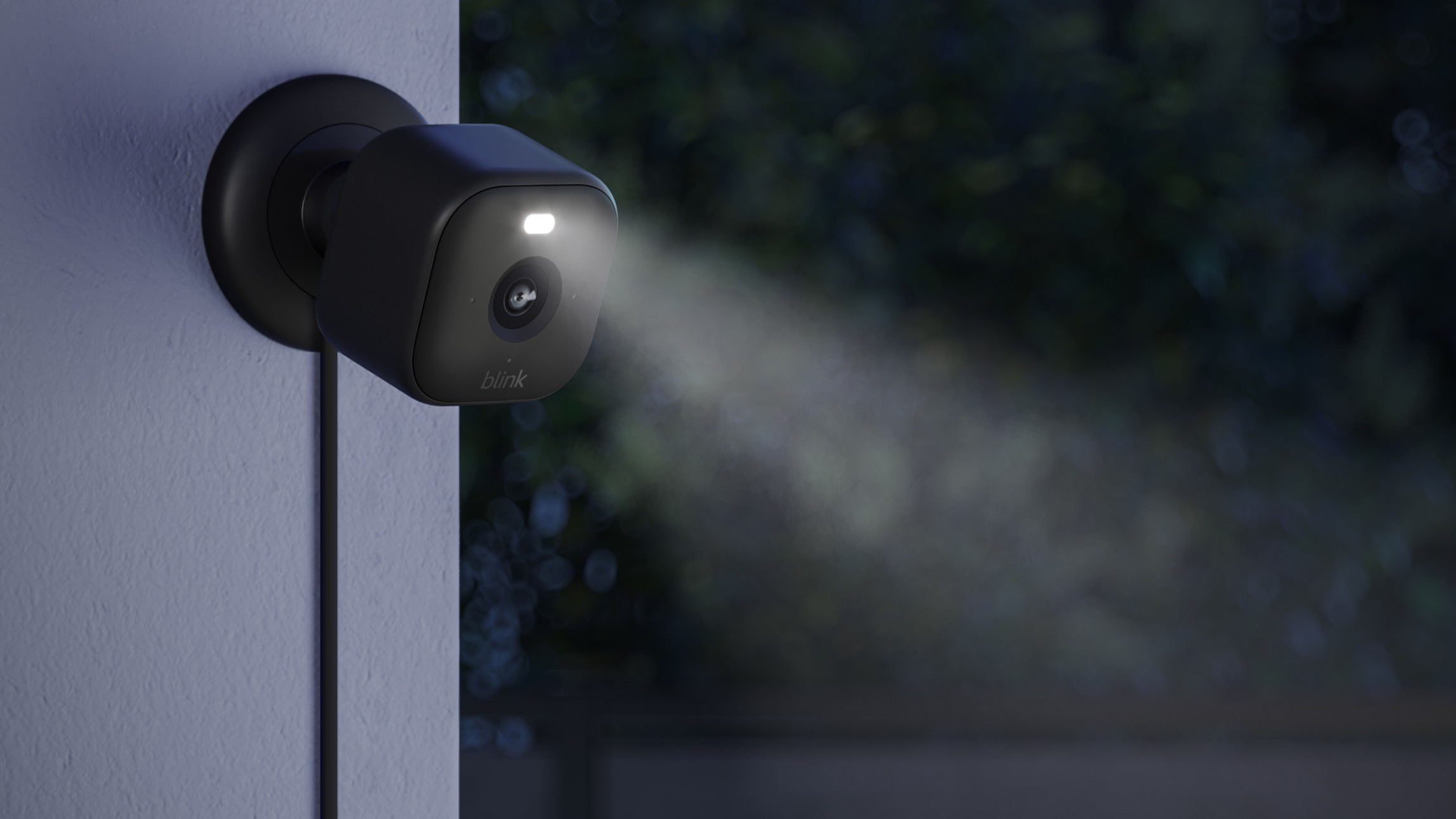 Blink Outdoor camera on wall at night with spotlight