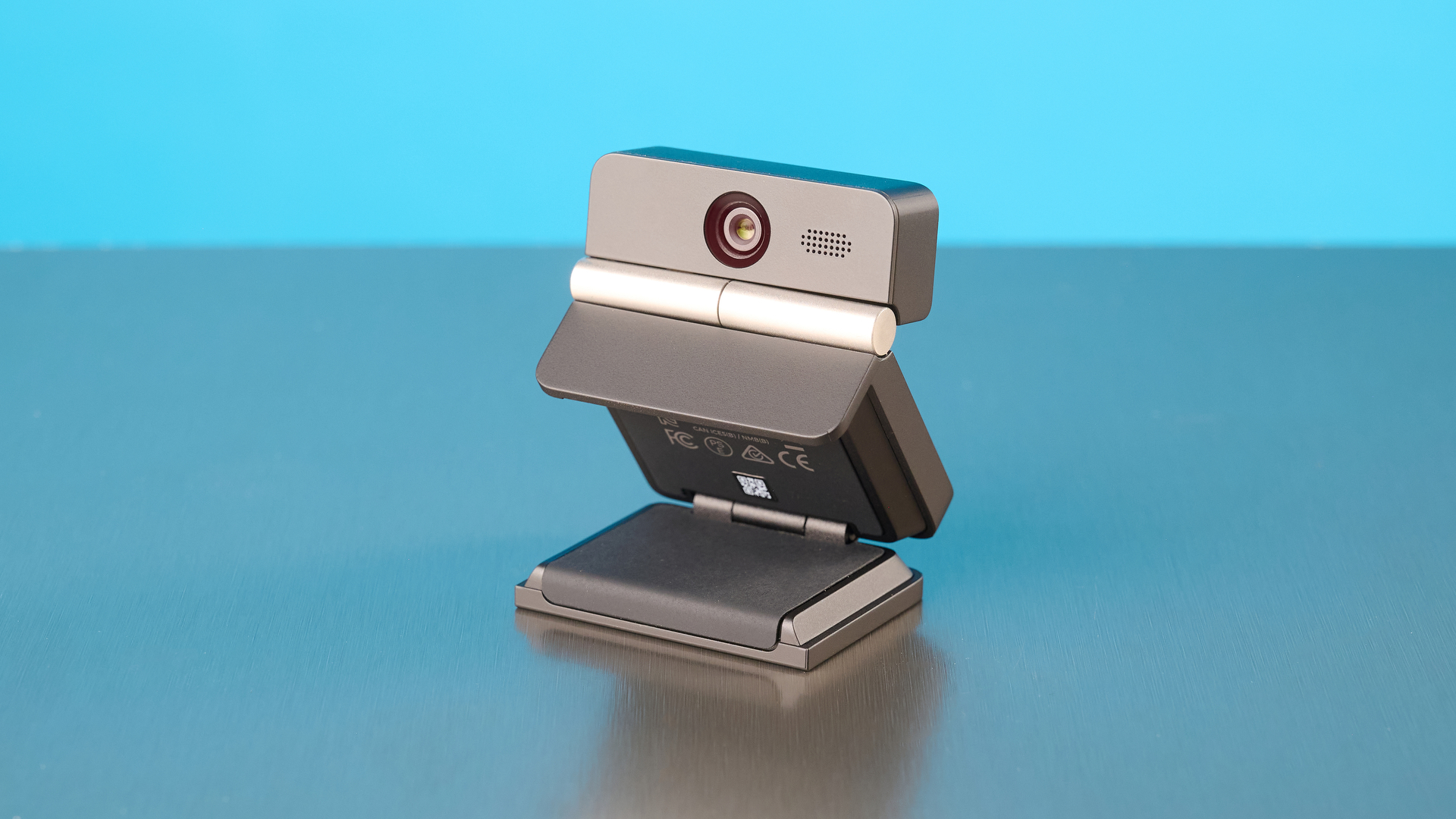 Obsbot Meet Flip foldable webcam photographed in front of a blue background