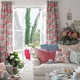 living room with floral curtains and flower vases