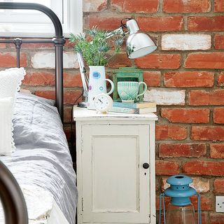 bedroom with brick wall and blue lantern