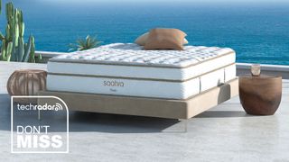 A Saatva Classic mattress on a bed frame by the sea