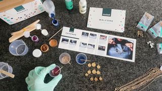 the contents of the Resin8 charmed necklace kit, with resin about to be poured into bezels