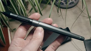 A photo of the Huion Q11K pen being held