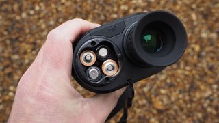 Bushnell Equinox Z2 6x50 Night Vision Monocular held in a hand showing the battery compartment full of batteries