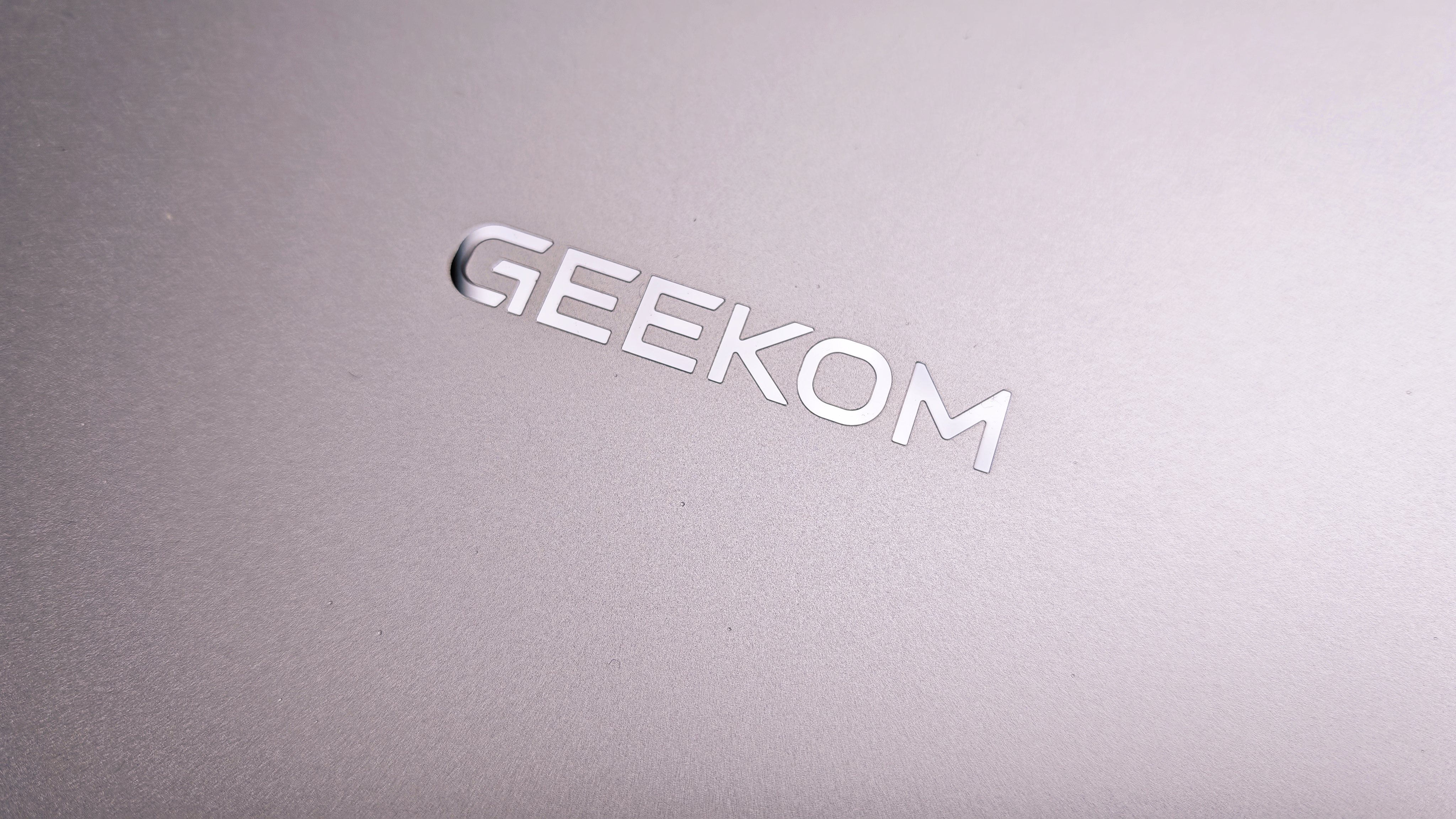 A silver Geekom GeekBook M16 laptop on a garden table