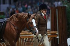 Robyn-Jayne Hadland leads Garlance Flash Jac our of the arena after suffering a broken stirrup at HOYS.