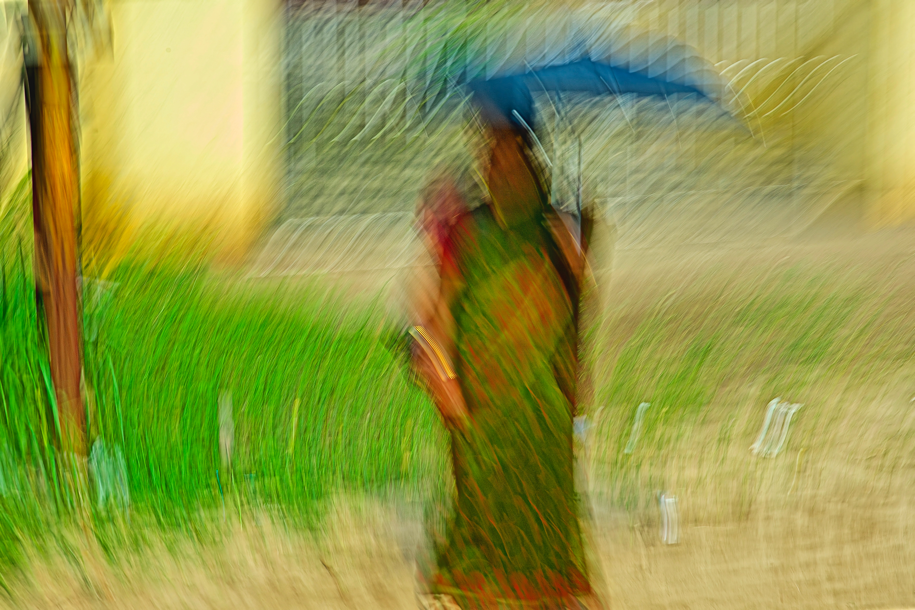 An abstract, motion-blurred figure in a green and red patterned garment carries a dark blue umbrella against a backdrop of soft yellow and bright green textures.
