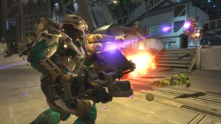 Master Chief firing at an alien with a huge gatling gun