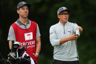 Rickie Fowler of the United States talks with his caddie Joe Skovron