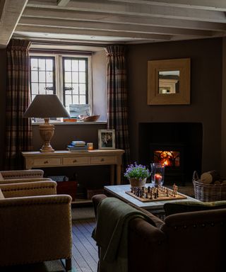 Traditional country living room with brown decor and fireplace, styled by Sims Hilditch